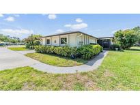 Charming single-story home with well-maintained landscaping and a welcoming walkway at 1339 Queen Anne Dr # C, Palm Harbor, FL 34684