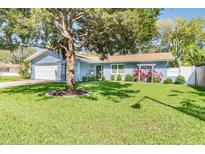 Charming single-story home featuring a lush lawn and mature landscaping with a pergola in a tranquil setting at 13749 80Th Ave, Seminole, FL 33776