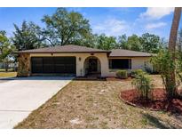 Charming single-story home featuring stone accents, a two-car garage, and a well-maintained front lawn at 2072 Maguire Ave, Spring Hill, FL 34608