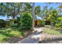 Charming home featuring a colorful exterior, mature landscaping, and a welcoming walkway at 220 22Nd Se Ave, St Petersburg, FL 33705