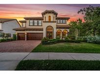 Stunning two-story home featuring a barrel tile roof, manicured landscaping, and a three-car garage at 3100 Barbour Trl, Odessa, FL 33556
