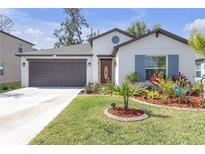 Charming single-story home with a well-manicured lawn and colorful landscaping at 36568 Garden Wall Way, Zephyrhills, FL 33541