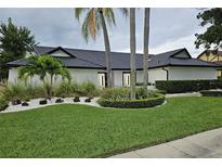 Stunning single-story home with lush green lawn, palm trees, and elegant landscaping at 7108 Pelican Island Dr, Tampa, FL 33634