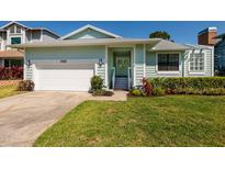 Charming, light-green, single-story home with a well-manicured lawn and a white garage door at 733 Captiva Ne Ct, St Petersburg, FL 33702