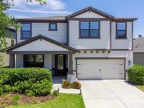Charming two-story home with a well-maintained lawn, inviting front porch and a two car garage at 1220 Florablu Dr, Seffner, FL 33584