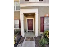 Inviting front entrance features a dark-red door and a decorative welcome mat at 12367 Foxmoor Peak Dr, Riverview, FL 33579
