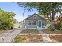 Charming bungalow-style home with blue door and mature landscaping, shaded by a mature tree and welcoming walkway at 2235 Burlington N Ave, St Petersburg, FL 33713