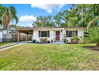 Charming single-story home with a well-manicured lawn, carport, and inviting front porch at 511 San Jose Dr, Dunedin, FL 34698