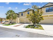 Charming townhome exterior featuring a 2-car garage, landscaped front yard, and a clear view on a sunny day at 5150 Bay Isle Cir, Clearwater, FL 33760