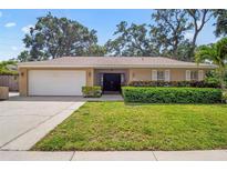 Charming single-story home with a lush green lawn, well-maintained landscaping, and a two-car garage at 5600 Bay Pines Lakes Blvd, St Petersburg, FL 33708