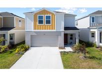 Two-story home with an attached garage, neutral colors and a well-maintained lawn at 7797 Peace Lily Ave, Wesley Chapel, FL 33545