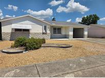 Charming home exterior with stone accents, awning, and low-maintenance landscaping at 7812 Heather St, New Port Richey, FL 34653