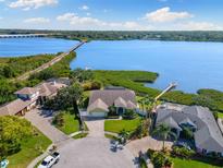 Stunning aerial view of waterfront home with lush landscaping and private dock on a sunny day at 826 Christina Cir, Oldsmar, FL 34677