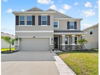 Stunning two-story home featuring a two-car garage, landscaped front yard, and welcoming front porch at 8607 Bower Bass Cir, Wesley Chapel, FL 33545