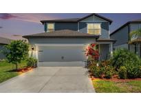 Charming two-story home featuring an attached two car garage and beautiful landscaping at 21003 Monza Loop, Land O Lakes, FL 34638