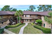 Exterior view of a two story condo community with walkways and lush landscaping at 2679 Sabal Springs Cir # 102, Clearwater, FL 33761