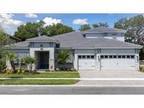 Attractive single-Gathering home with manicured lawn, neutral paint, a gray roof, stone accents and a three-car garage at 4517 Foley Grove Dr, Valrico, FL 33596