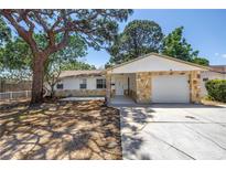 Charming single-story home with stone accents, a well-manicured lawn, and mature shade trees at 518 62Nd Ne Ave, St Petersburg, FL 33702