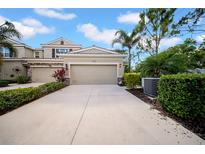 Inviting townhome featuring a driveway and attached garage, complemented by tropical landscaping at 5312 6Th N Way, St Petersburg, FL 33703