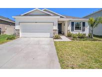 Charming single-story home with well-maintained lawn and a two-car garage at 5464 Flint Hills Dr, Wimauma, FL 33598