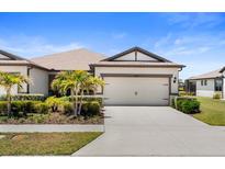 Charming single-Gathering home featuring a well-manicured lawn, two-car garage, and lush landscaping at 6206 Mooring Line Cir, Apollo Beach, FL 33572