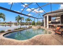 Outdoor pool with spa and covered outdoor kitchen overlooking the lake; perfect for entertaining at 13208 Malachite Dr, Bradenton, FL 34211