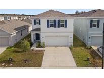 Charming two-story home with blue shutters and a well-manicured front lawn at 15959 Tuscany Hillside Rd, Odessa, FL 33556