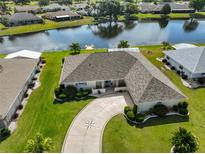 Aerial view of home featuring well-manicured lawn, mature landscaping and decorative concrete driveway at 2003 Wedge Ct, Sun City Center, FL 33573