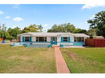 Charming single-story home featuring a brick walkway, turquoise accents, and a well-manicured lawn at 4421 28Th N Ave, St Petersburg, FL 33713