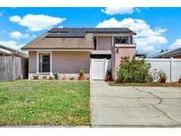 Charming two-story home featuring solar panels and a well-maintained front yard at 5137 Springwood Dr, Tampa, FL 33624