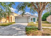 Charming single-story home featuring a well-maintained lawn, two-car garage and quaint front porch and an inviting turquoise door at 8561 Deer Chase Dr, Riverview, FL 33578