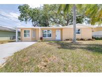 Charming single-story home with a white door and well-maintained front yard at 13926 Helen Ave, Hudson, FL 34667