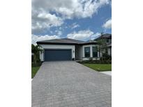 Charming single-story home with a blue garage door and paver driveway at 17116 Moonflower Dr, Venice, FL 34293