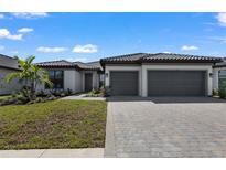Beautiful single-story home featuring a two-car garage, manicured landscaping, and a neutral color palette at 1797 Pepper Grass Dr, North Port, FL 34289