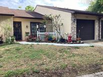 Charming single-story home featuring a well-manicured lawn and attached one-car garage at 2101 Sunset Point Rd # 205, Clearwater, FL 33765