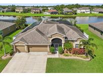 Aerial view of a beautiful house with a backyard pond and lush landscaping at 2417 Cumberland Cliff Dr, Ruskin, FL 33570