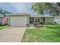 Charming single-story home featuring a well-maintained lawn and a two-car garage at 29436 Zeller Ave, San Antonio, FL 33576