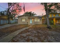 Charming single-story home features a well-kept lawn, mature trees, and welcoming front entrance at 306 S Highland Ave, Clearwater, FL 33755
