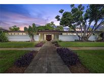 Stunning mid-century modern home featuring lush landscaping and a symmetrical facade at 3501 S Drexel Ave, Tampa, FL 33629