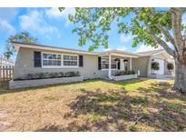Charming single-story home featuring a well-maintained lawn and beautiful curb appeal with mature landscaping under a sunny sky at 3540 Cockatoo Dr, New Port Richey, FL 34652