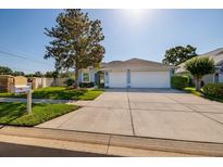 Charming single-story home with well-maintained landscaping, a spacious driveway, and a two-car garage at 4997 W Breeze Cir, Palm Harbor, FL 34683