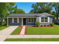 Charming home featuring a well-manicured lawn, stone accents, and a welcoming entrance at 10931 110Th Ave, Seminole, FL 33778