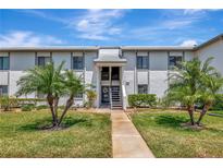Charming two-story condo with a well-manicured lawn, mature palm trees, and welcoming entryway at 112 W Cypress Ct, Oldsmar, FL 34677