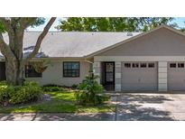 Charming single-story home with a well-manicured lawn and attached garage at 1542 Rebecca Ln, Dunedin, FL 34698