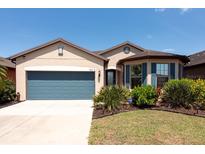 Charming single-story home featuring a well-manicured lawn and a two-car garage, great curb appeal at 16313 Treasure Point Dr, Wimauma, FL 33598