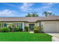 Charming single-story home with a well-manicured lawn, lush landscaping, and an attached garage at 18807 Tournament Trl, Tampa, FL 33647
