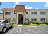 Condo building with brown roof and stairs leading to units, surrounded by landscaping at 381 S Mcmullen Booth Rd # 72, Clearwater, FL 33759