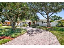 Charming single-story home featuring a brick driveway, lush landscaping, and inviting curb appeal at 430 44Th Ne Ave, St Petersburg, FL 33703