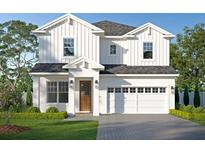 Stunning two-story white home featuring a symmetrical facade, a two-car garage, and a well-manicured lawn at 4316 S Renellie Dr, Tampa, FL 33611