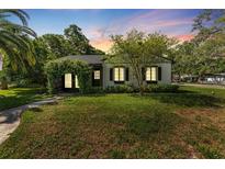 Charming single-story home with a well-manicured lawn and an inviting, plant-covered archway entrance at 433 San Salvador Dr, Dunedin, FL 34698